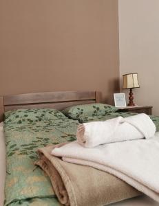 - une chambre avec un lit et des serviettes dans l'établissement Kata's Place, à Subotica