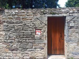 eine Backsteinmauer mit einer Holztür mit einem Schild darauf in der Unterkunft La Vie Là, Chasselay in Chasselay