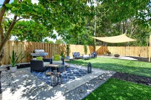 a backyard with a patio with chairs and a fence at Boynton Beach Getaway in Boynton Beach