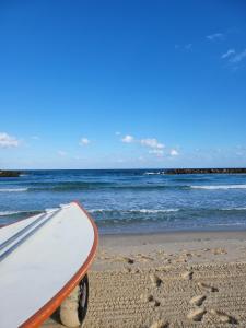 a surfboard sitting on a sandy beach next to the ocean at Crazy Suite in Ashkelon