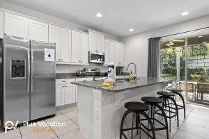una cucina con frigorifero in acciaio inossidabile e sgabelli da bar di 320-Luxury Villa w POOL&Hot Tub a Orlando