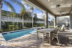 奥兰多320-Luxury Villa w POOL&Hot Tub的游泳池旁带桌椅的天井