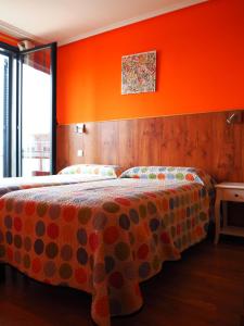 a bedroom with a bed with an orange wall at Apartamento Golf Buenas Vistas in Cirueña +104 photos