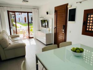 馬斯帕洛馬斯的住宿－Apartamentos Los Balandros by SunHousesCanarias，厨房以及带一碗水果的桌子的客厅。