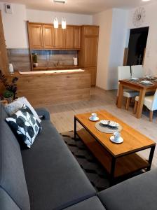 una sala de estar con un sofá y una mesa en Apartament Green Park, en Starogard Gdański