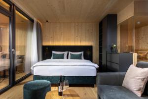 1 dormitorio con 1 cama y 1 sofá en Der Dolomitenhof - Tristach, en Lienz