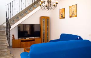 ムロにあるCasa Marimar 039 by Mallorca Charmeのリビングルーム(青いソファ、テレビ付)