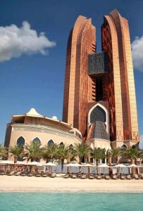 a resort with tables and chairs in front of a building at Bab Al Qasr Residence in Abu Dhabi