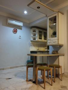 cocina con mesa de madera y taburetes en Glory beach resort private apartment en Port Dickson