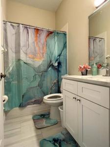 uma casa de banho com uma cortina de chuveiro e um WC em Chic villa 4 Bedroom 3 Bath with pool & game room em Davenport