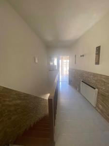 an empty room with a staircase and a brick wall at casa de pueblo con chimenea in Navas del Rey