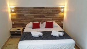 a bedroom with a large bed with two red pillows at STUDIOS PARISIENS in Cannes