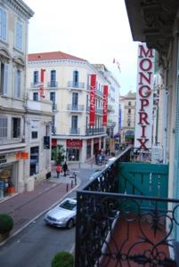 einen Balkon mit Blick auf eine Stadtstraße mit Gebäuden in der Unterkunft STUDIOS PARISIENS in Cannes