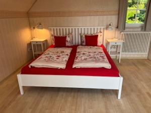 ユーバーリンゲンにあるFerienwohnung Bodenseeのベッドルーム1室(大型ベッド1台、赤い枕付)