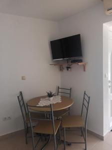 stół jadalny z krzesłami i telewizor na ścianie w obiekcie Volat Apartments w mieście Betina
