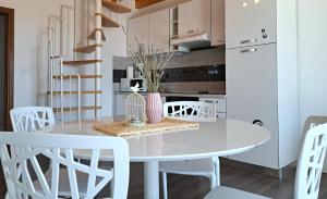 Un comedor blanco con una mesa y sillas blancas. en Apartment Oaza Mira, en Tribunj