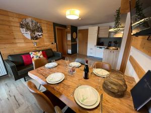 ein Esszimmer mit einem Holztisch mit Tellern und Weingläsern in der Unterkunft Apartments Chalet Sonnentanz in Piesendorf