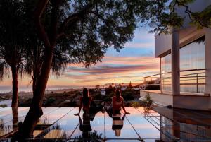 two women are standing on a swimming pool in front of a house at Marbella Boutique Art suites in Marbella