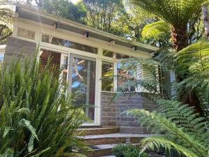 a brick house with a window and some plants at Lala Haus Gramado in Gramado