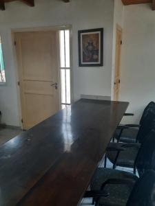 una gran mesa de madera en una habitación con sillas en Complejo las Palmeras II en Mendoza