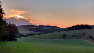 a sunset on a golf course with a green field at Ferienwohnung am Ring in Baar