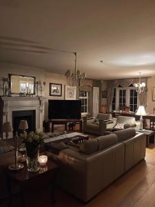 a living room with a couch and a piano at Redgate House Bed & Breakfast in Derry Londonderry