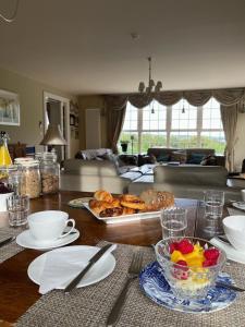 a table with a bowl of fruit and a plate of food at Redgate House Bed & Breakfast in Derry Londonderry