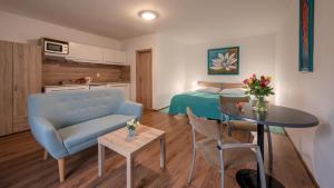 a room with a bed and a blue couch and a table at Apartmany Tereza & free parking in Bratislava