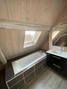 a bathroom with a bath tub and a sink at Maison chaleureuse avec cheminée 