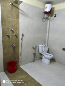 a bathroom with a shower and a toilet in a stall at Villa de hollong in Mādāri Hāt