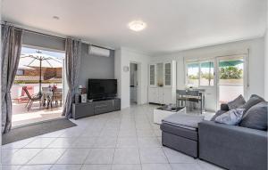 uma sala de estar com um sofá e uma televisão em Stunning Apartment In Roquetas De Mar With House A Mountain View em Roquetas de Mar