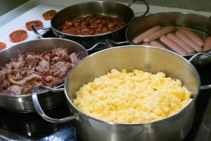 una estufa con tres sartenes de comida en una estufa en Hotel Turin Barcelona, en Barcelona