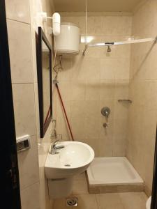 a small bathroom with a sink and a shower at شاليهات بورتو ساوث بيتش عائلات in Ain Sokhna