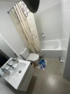 y baño con lavabo, aseo y bañera. en Pleno Centro Apart, en Antofagasta