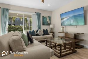 a living room with a couch and a tv at 520-Villa by Disney 8 Bedrooms wPool & SPA in Orlando