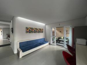 a living room with a blue couch on a wall at Guaicurus Hotel in Chapadão do Sul