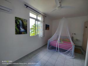 a bedroom with a bed with a mosquito net at Luketo in Vieux-Habitants