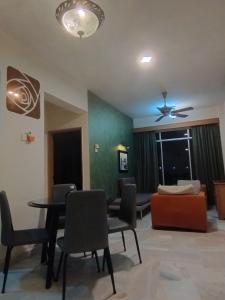 een woonkamer met een tafel en stoelen en een bank bij GloRy BeAch ResOrt private apartment in Port Dickson