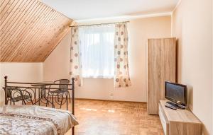 Habitación con cama, mesa y TV. en 7 Bedroom Lovely Home In Pasym en Pasym