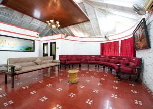 a living room with red chairs and a couch at Sugam Resort & Convention Centre in Chennai