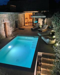 a swimming pool in a backyard at night at Mikro1890 in Mesogi