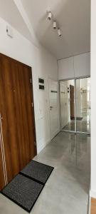 ein großes leeres Zimmer mit einer Holztür und Spiegeln in der Unterkunft Uroczy apartament - Krasnystaw in Krasnystaw
