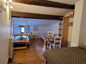 a bedroom with a bed and a desk and a table at Grande maison de montagne rénovée, du charme in Rodome