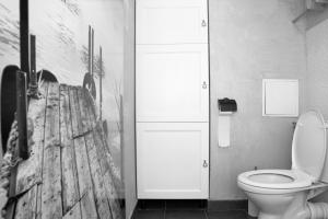 a bathroom with a toilet and a painting on the wall at Apartament EL Romano in Gdynia
