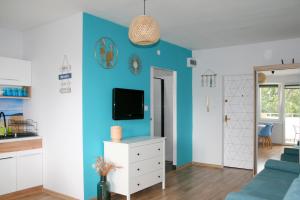 a living room with a blue accent wall at Apartament EL Romano in Gdynia