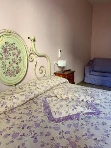 - une chambre dotée d'un lit avec un couvre-lit floral dans l'établissement Da Giusy, à Stresa