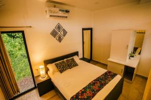 Habitación pequeña con cama y ventana en Good vibes en Kallar Vattiyar