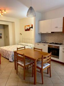 uma cozinha com uma mesa e cadeiras de madeira e uma cama em Da Giusy em Stresa