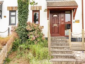 a house with a wooden door and stairs in front at Padstowgetaways in Padstow
