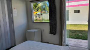 een kamer met een raam en een bed en een raam bij Pousada Sol Nascente in Guaibim